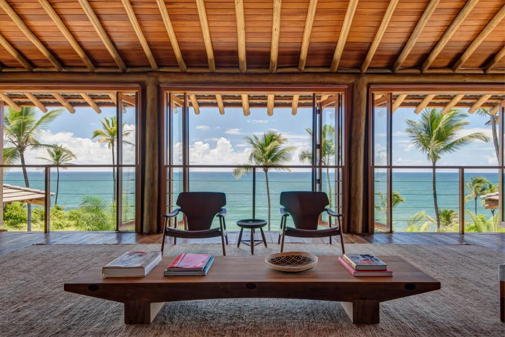 Resort guest-suite opening with two lounge chairs facing palms and the sea