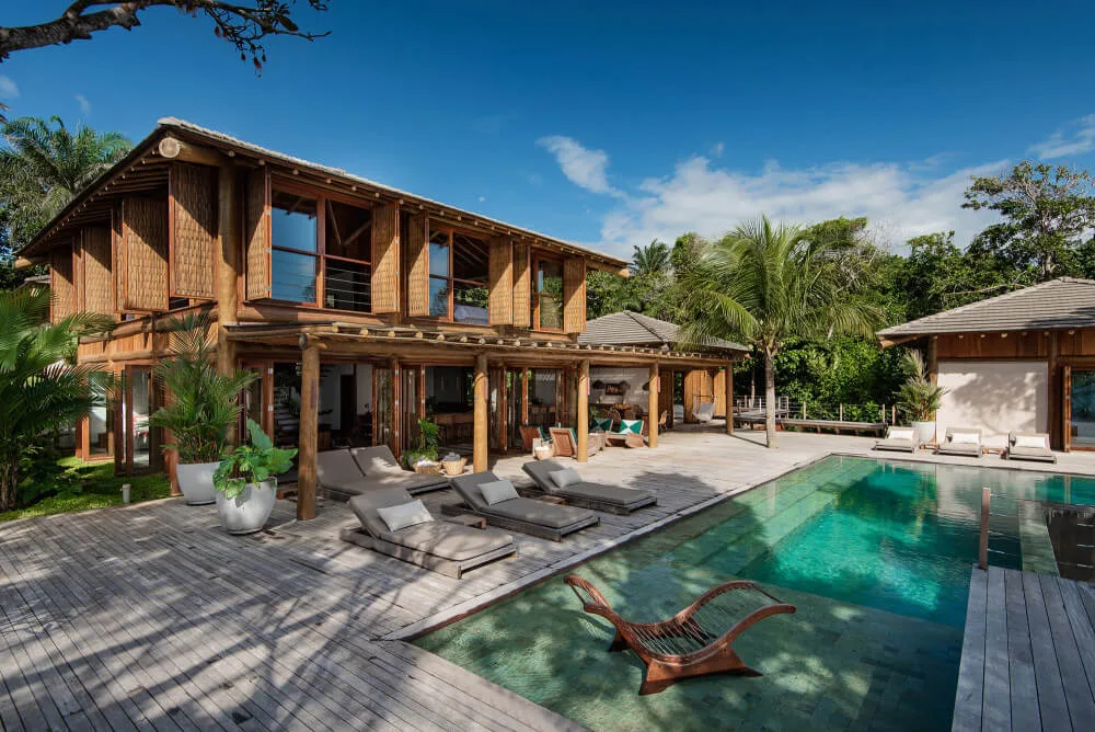 Resort courtyard with a swimming pool, deck loungers, separate seating and surrounding guest buildings